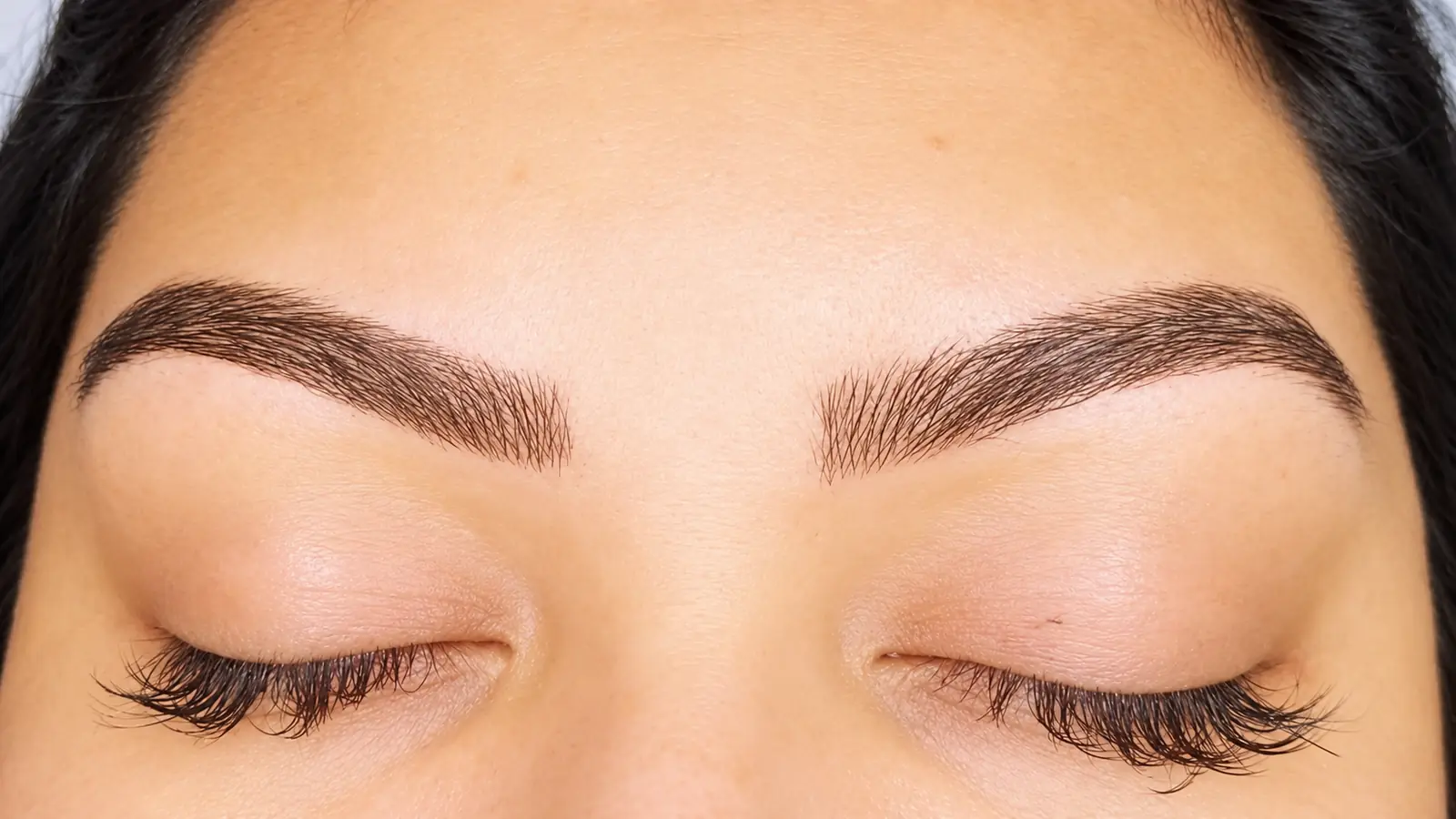 A client's brows photographed with the eyes closed, after brow work.